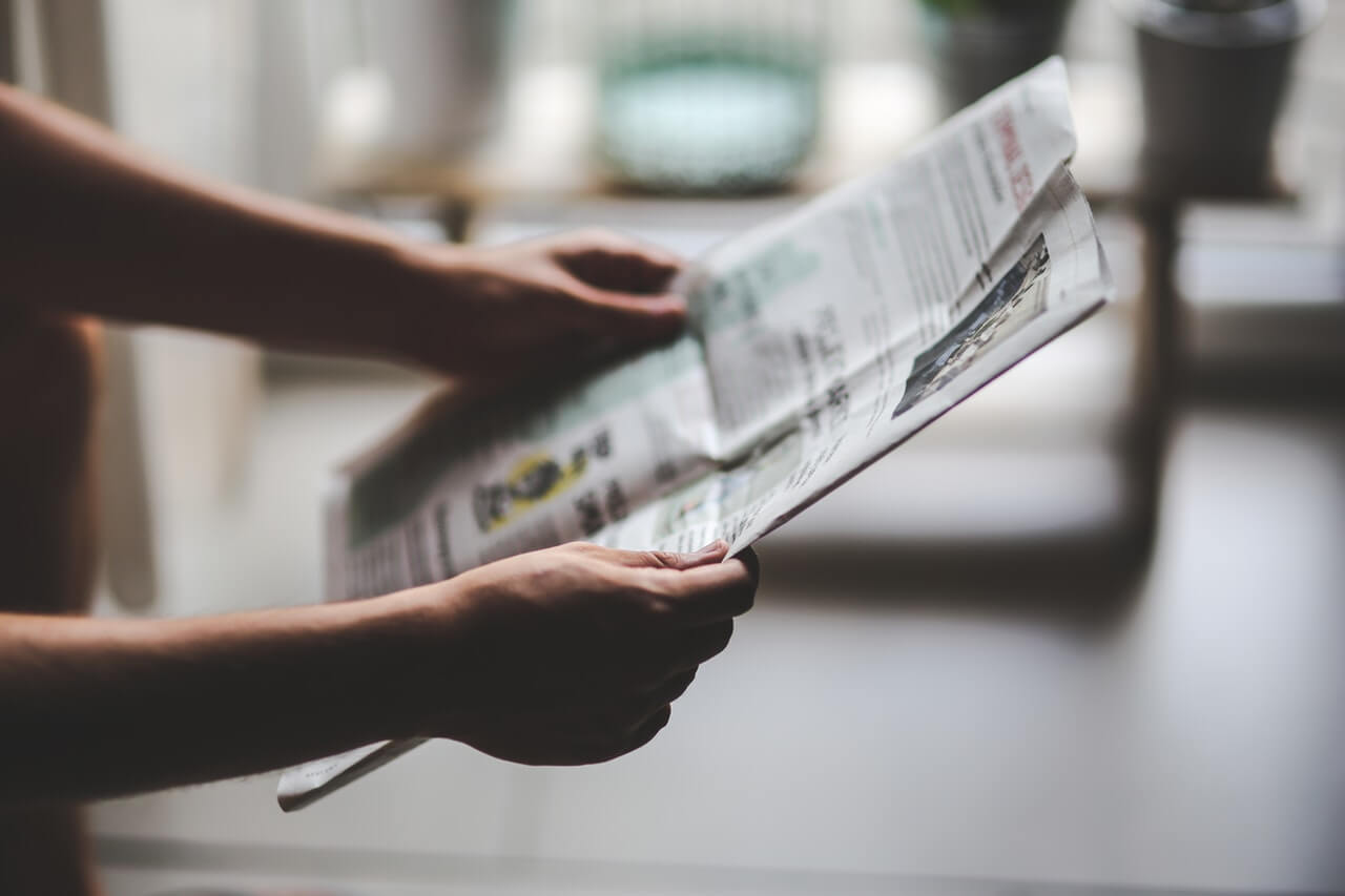 Close%20up%20of%20a%20person%20holding%20a%20newspaper Close up of a property manager holding a newspaper manage